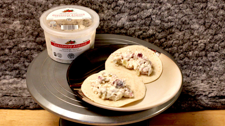A plate of tortillas with Park Street Deli Cranberry Almond Chicken salad beside the container for the chicken salad