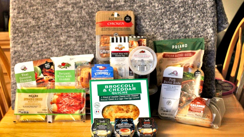 A selection of prepared and refrigerated food options from Aldi featuring savory selections from Park Street Deli and Mamma Cozzi as well as sweet desserts from Specially Selected