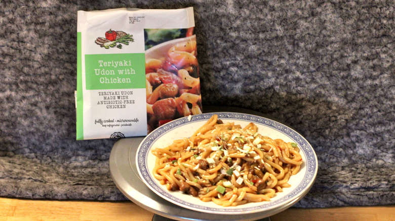 A plate of Park Street Deli Teriyaki Udon with Chicken beside the package it came in