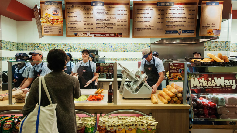 A customer talking to workers at Jersey Mike's