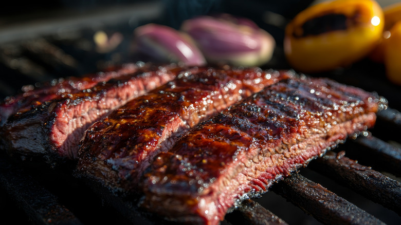 Skirt steak on a grill with onions and bell pepper