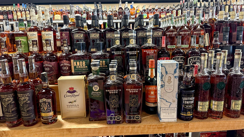 Store shelf with many different bottles of whiskeys and bourbons