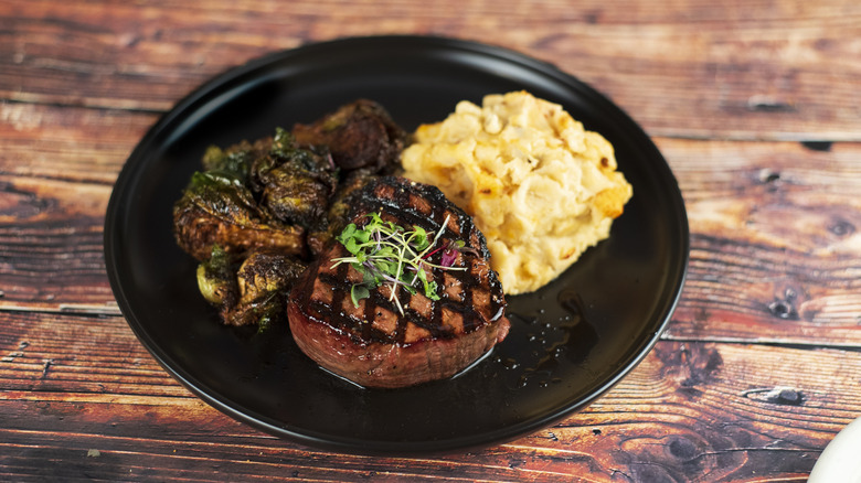 Steak on plate with veggies and potato sides