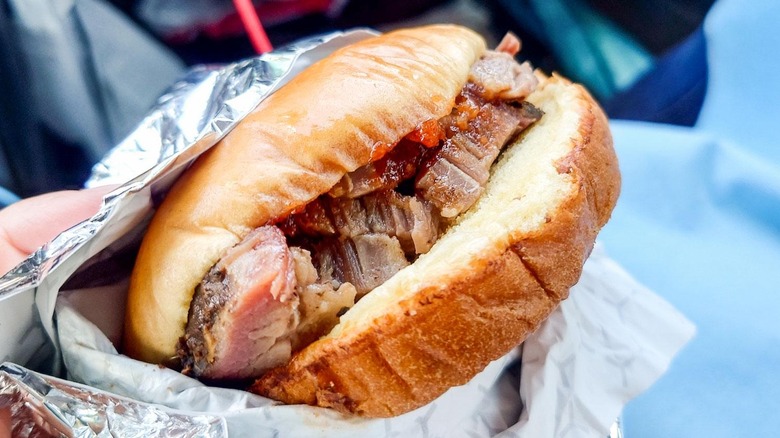 Someone holding the Chopped Brisket Sandwich from Buc-ee's.