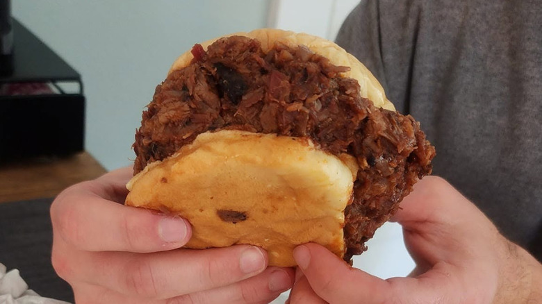 A man holding the Pulled Pork BBQ from Buc-ee's.