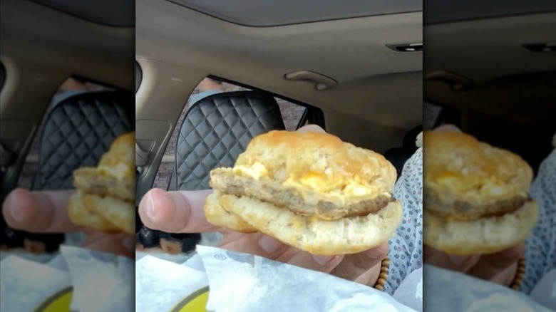 A man holding the Sausage, Egg and Cheese Biscuit from Buc-ee's.