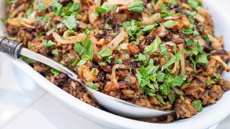 Serving dish of Mujaddara with a silver spoon