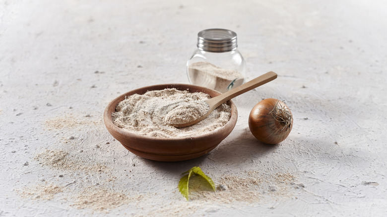 Bowl of white powder with an onion and jar on the side