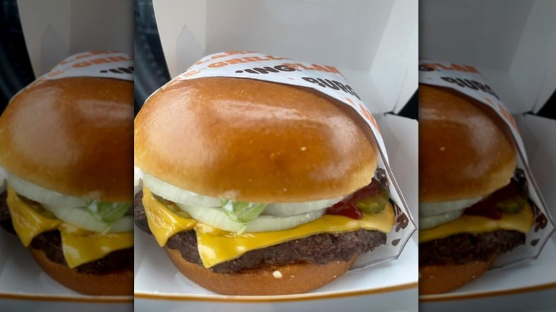 A new Burger King whopper sitting in a box.