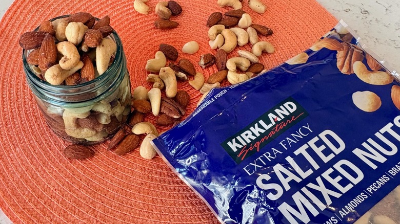 An open bag and bowl of Kirkland Signature salted mixed nuts