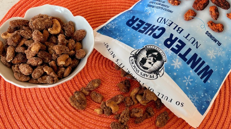 An open bag and bowl of Pear's Snacks winter cheer nut blend from Costco