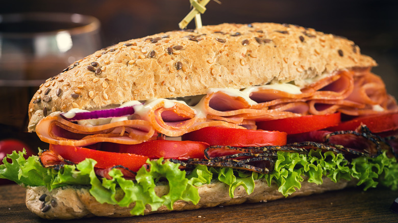A deli sub sandwich on a wooden surface
