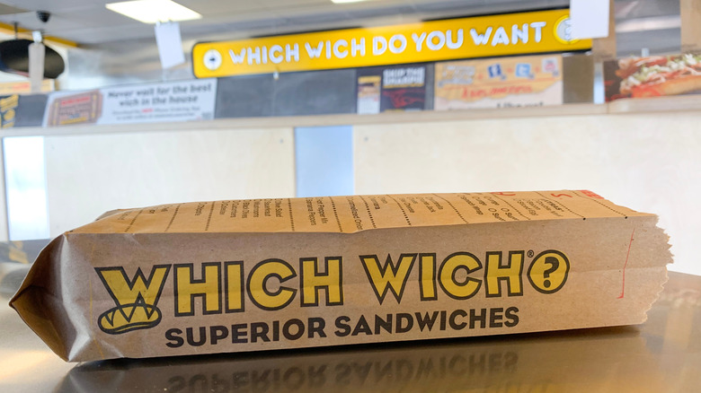 Which Wich sandwich close-up and sign behind