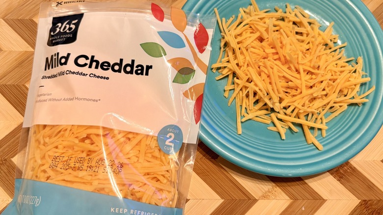 A bag and plate of 365 Whole Foods Market shredded milk cheddar cheese