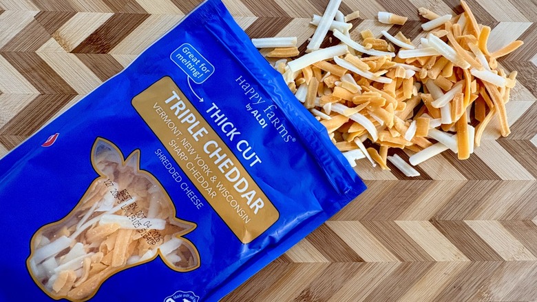 A open bag of Happy Farms by Aldi shredded triple cheddar cheese