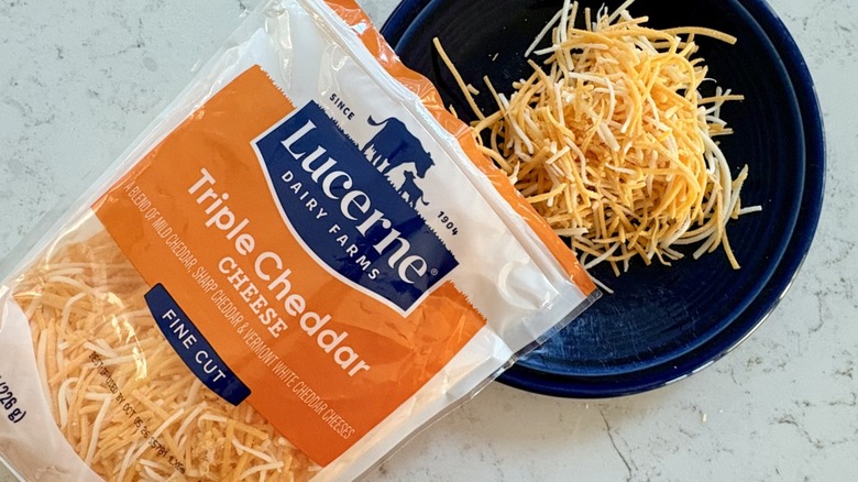 Lucerne Triple Cheddar shredded cheese poured onto plate