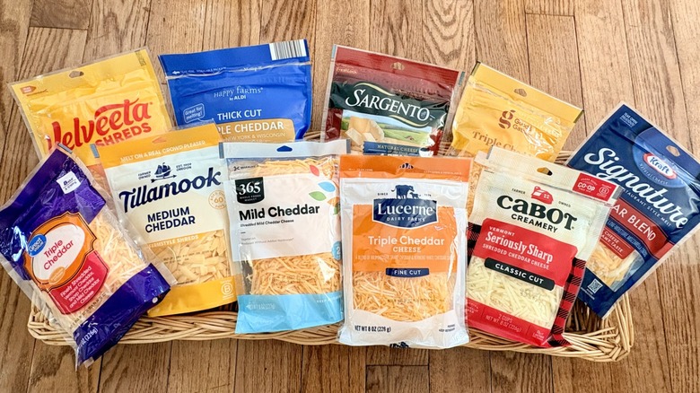 A basket filled with bags of shredded cheese from different brands
