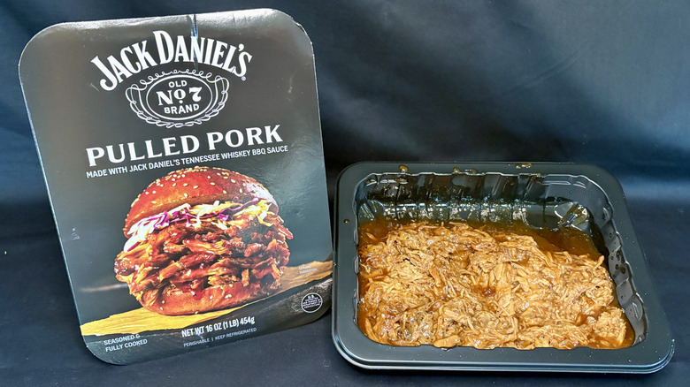 pulled pork in black container next to Jack Daniel's packaging