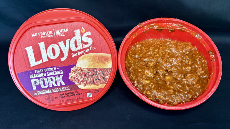 red tub of Lloyd's pulled pork with lid on side