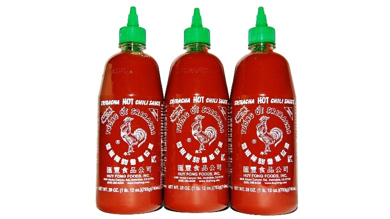 Three bottle of Huy Fong Sriracha on white background