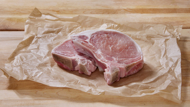 Raw pork chops on butcher paper on a table