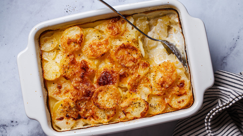 French classic potato gratin dauphinois in a white dish, top view.