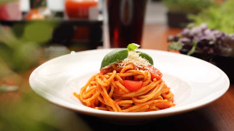 Plate of spaghetti pomodoro in front out of focus background