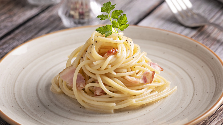 Carbonara on plate on wooden table