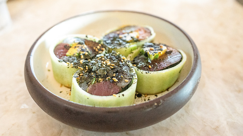 cucumber wrapped sushi pieces sprinkled with nori
