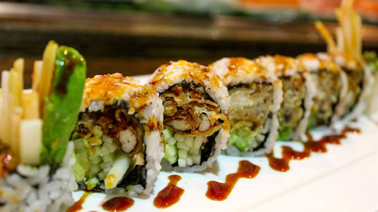 Spider sushi roll with fried crab, cucumber slices, and eel sauce