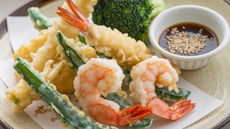 Shrimp and vegetable tempura served on white plate with dipping sauce