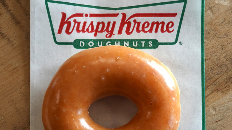 A Krispy Kreme Original Glazed doughnut on a Krispy Kreme branded napkin