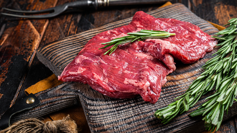 Raw alternative skirt beef steak on butcher board.