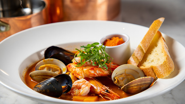 Bouillabaisse with bread in white bowl