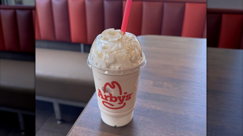 A milkshake sits on an Arby's table