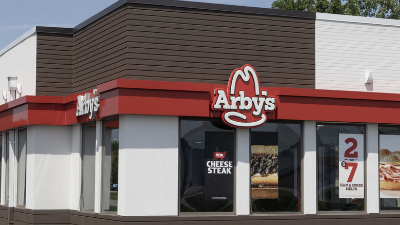 An Arby's storefront with advertisements showcasing its new items