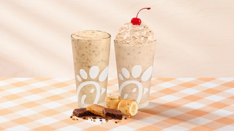 A product image of Chick-fil-A's S'mores Frosted Coffee and the S'mores Milkshake on a checkered tablecloth.