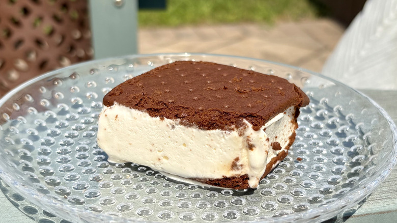 A FatBoy vanilla ice cream sandwich on a glass plate outside