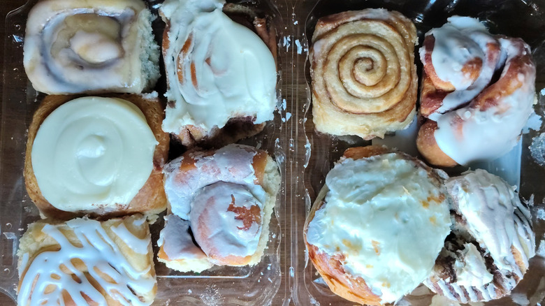 Nine different brands of cinnamon rolls with various glazes, icings, and frostings.