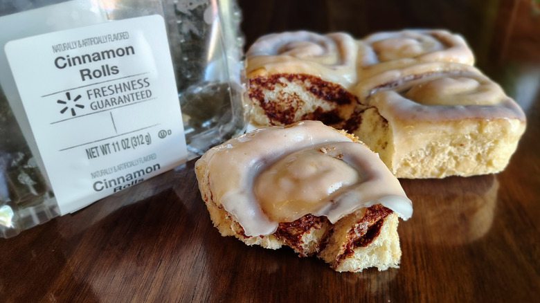 Freshness Guaranteed cinnamon rolls next to plastic clamshell packaging.