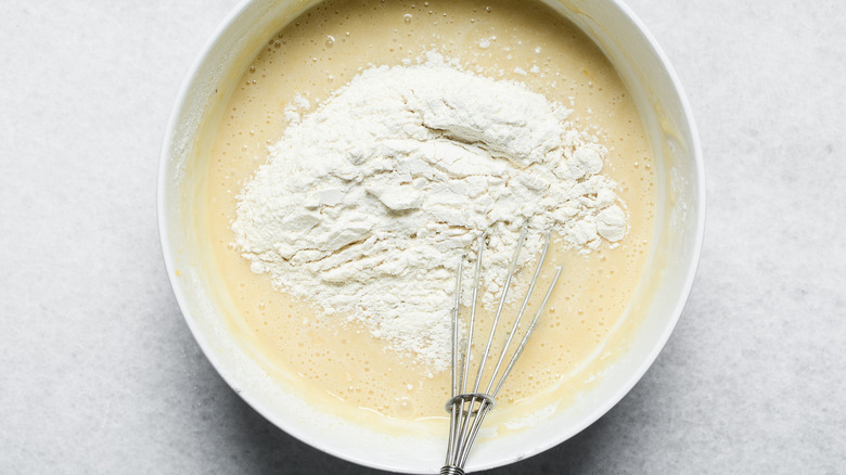Overhead view of flour being mixed into batter