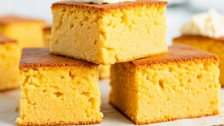 A pile of three squares pieces of fluffy cornbread