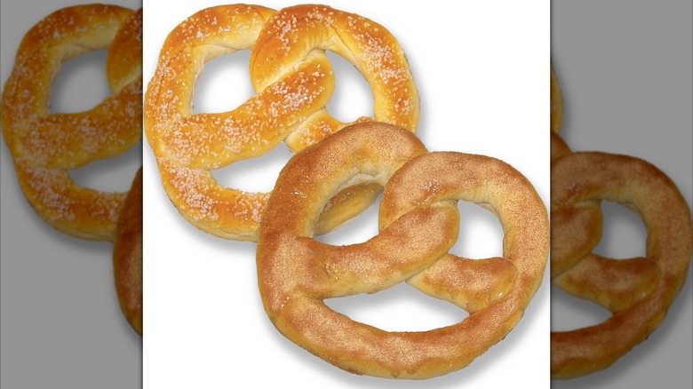 A cinnamon sugar large pretzel in front of a salted large pretzel, both from Sam's Club on a white background.