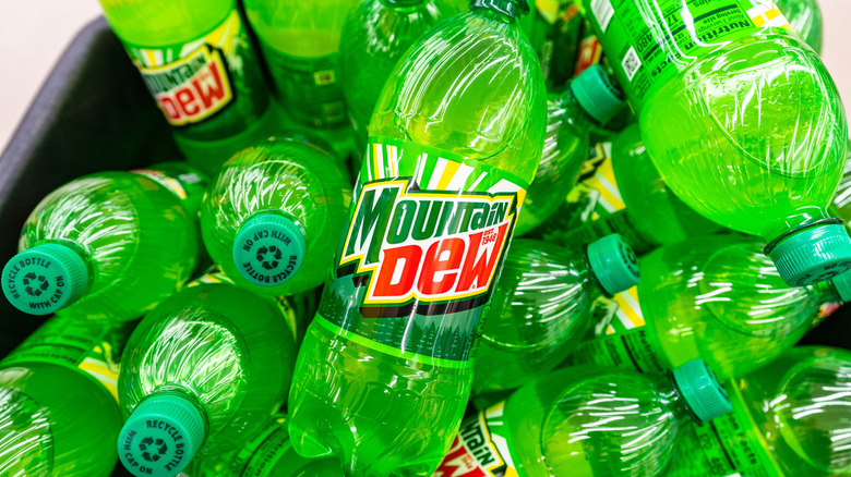 Bottles of Mountain Dew stacked on each other in a bucket.