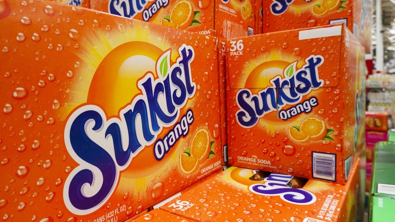 Stacked cases of Sunkist orange soda in a grocery store.