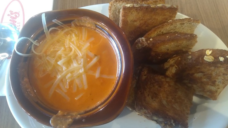 A bowl of Jason's Deli's Tomato Soup with slices of bread