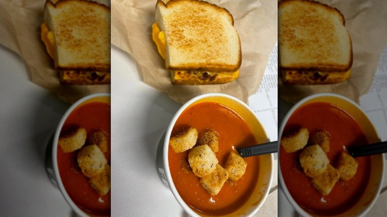 A bowl of Panera Bread's Creamy Tomato Soup with half a grilled cheese