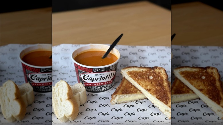A bowl of Capriotti's Sandwich Shop's Tomato Soup with its grilled cheese and pieces of bread