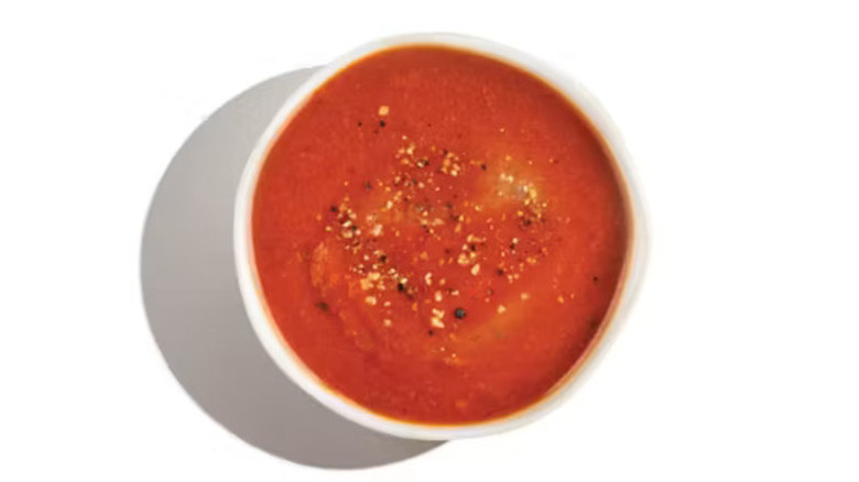 A bowl of the Tomato Soup from Zoup! with seasoning on top