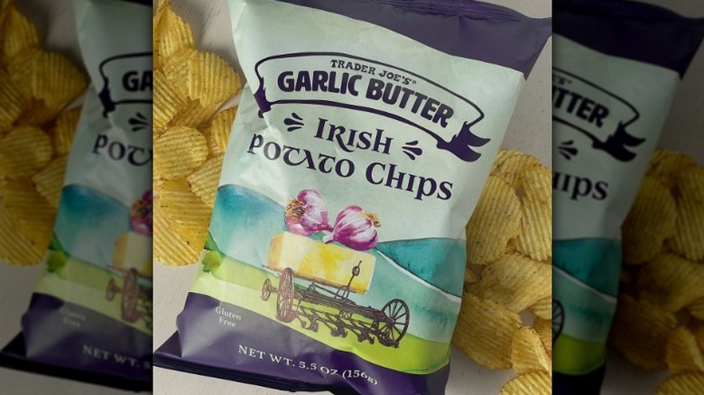 A bag of Trader Joe's Garlic Butter Irish Potato Chips, with the chips laying behind it.